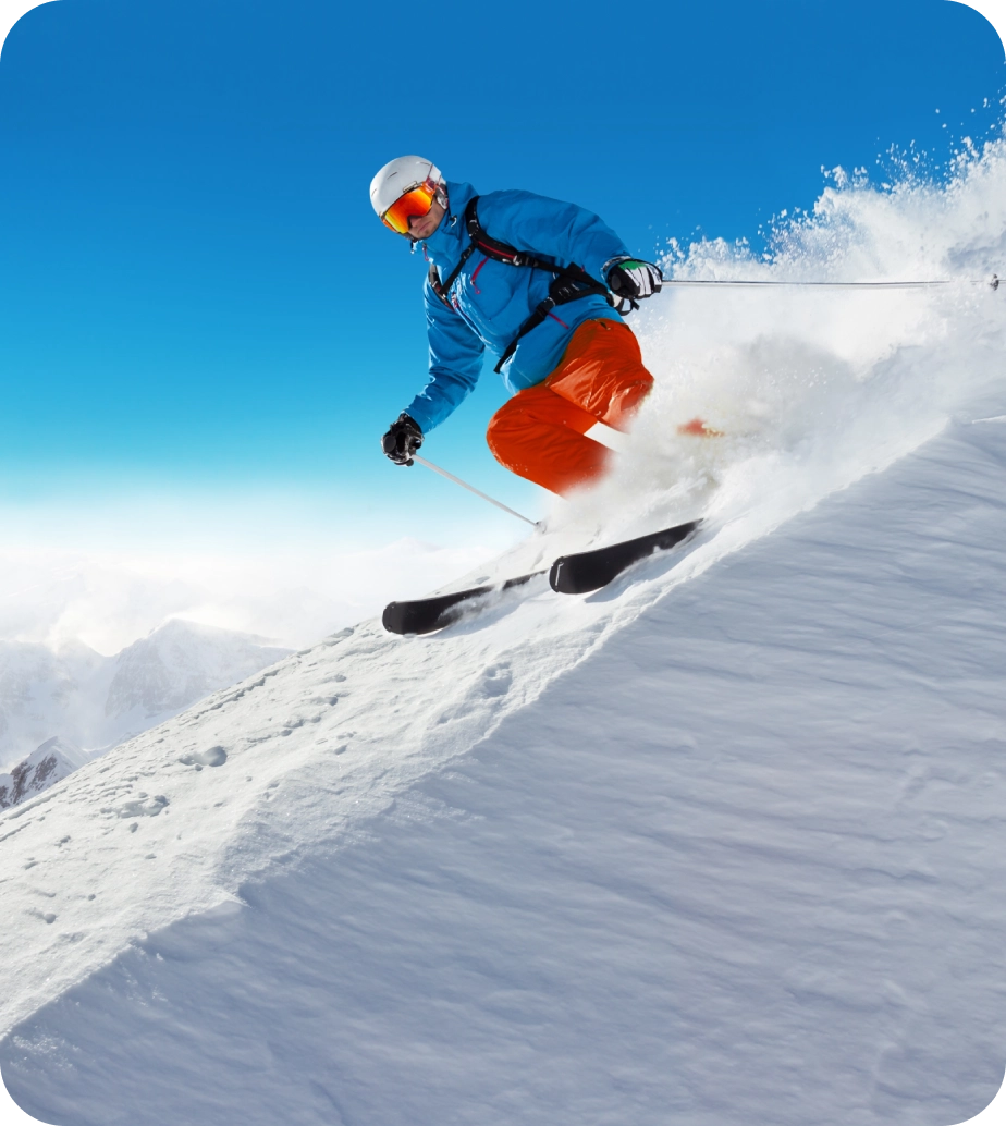 Here's an alt tag for the image: Skier carving down snowy mountain slope.