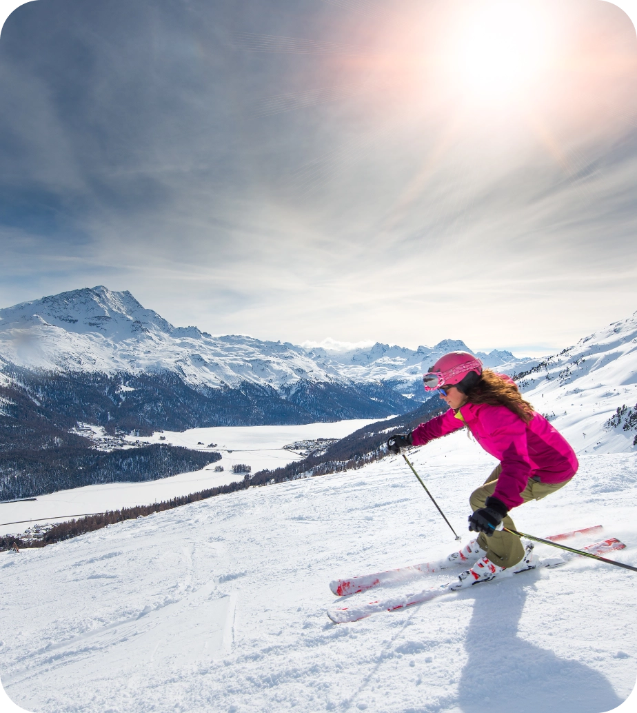 Woman skiing down snowy mountain slope.