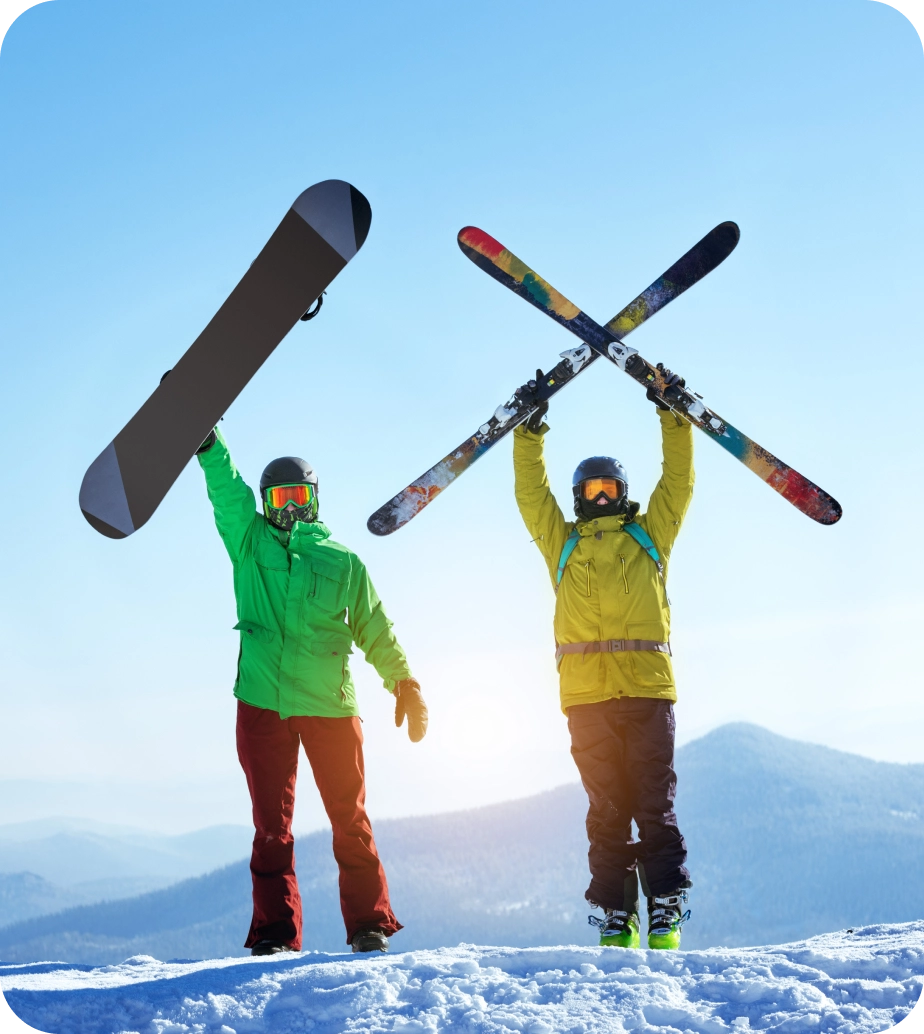 Snowboarder and skier celebrating on mountain.